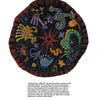 Designing & Hooking Primitive Rugs by Schiffer Publishing, Ltd. features step-by-step guidance to create round, embroidered textiles with colorful animals, abstract shapes, and a central red starburst for a playful, dreamlike look.