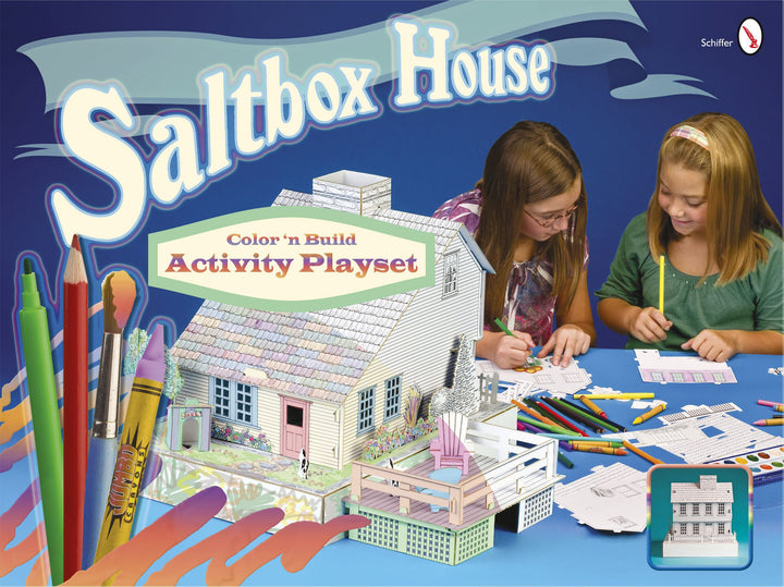 Two girls sit at a table coloring and assembling the Saltbox House by Schiffer Publishing. Art supplies and cut-outs are spread out, with "Saltbox House Activity Playset" text on a blue background featuring pencils and markers.